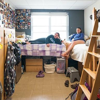 Two UNE 学生 watching television in their dorm room